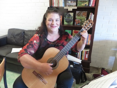 Naomi Millett playing classical guitar at Soul Tree Organic Cafe